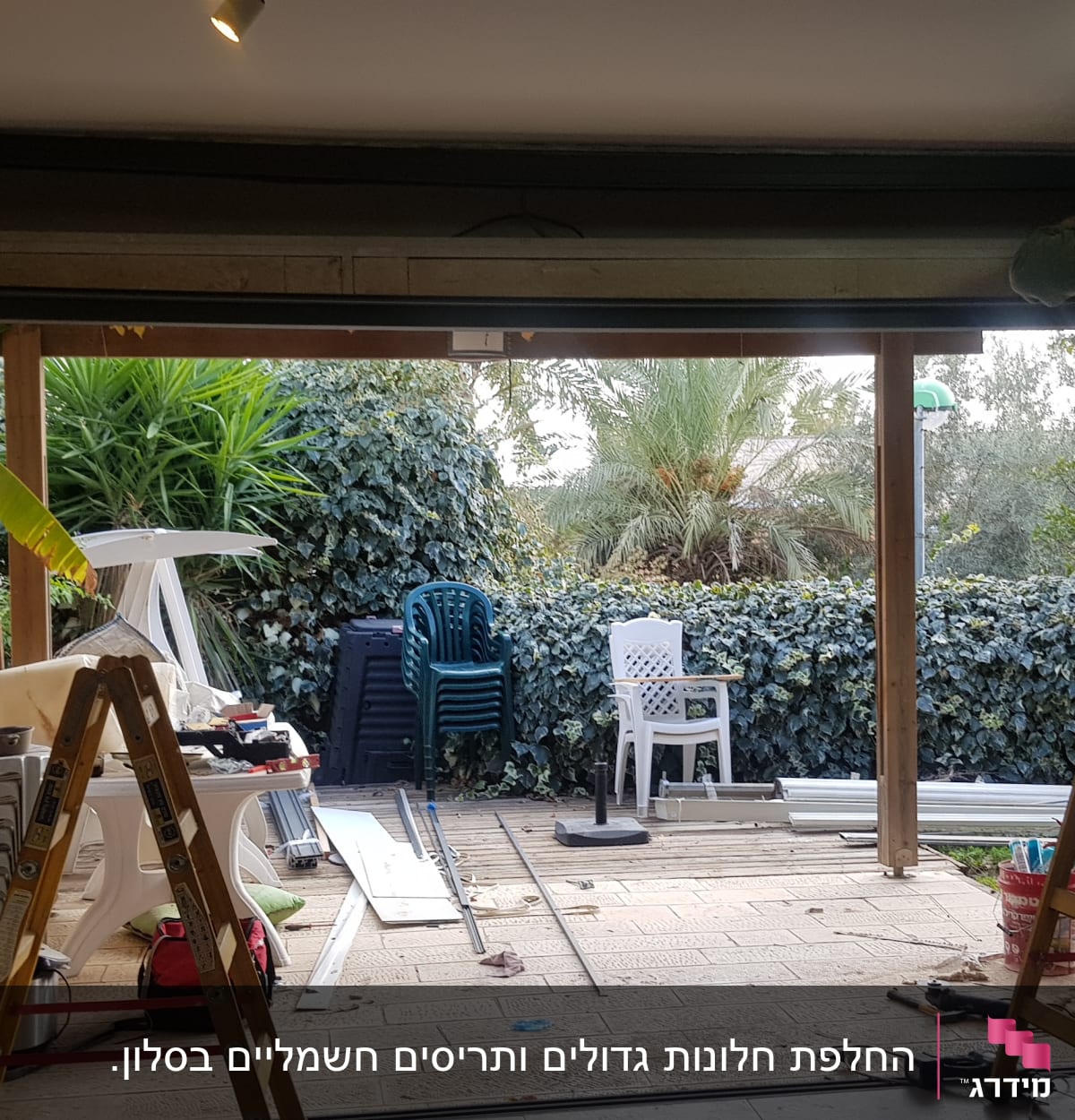 אדם עובד על מסגרת אלומיניום בדלת גדולה